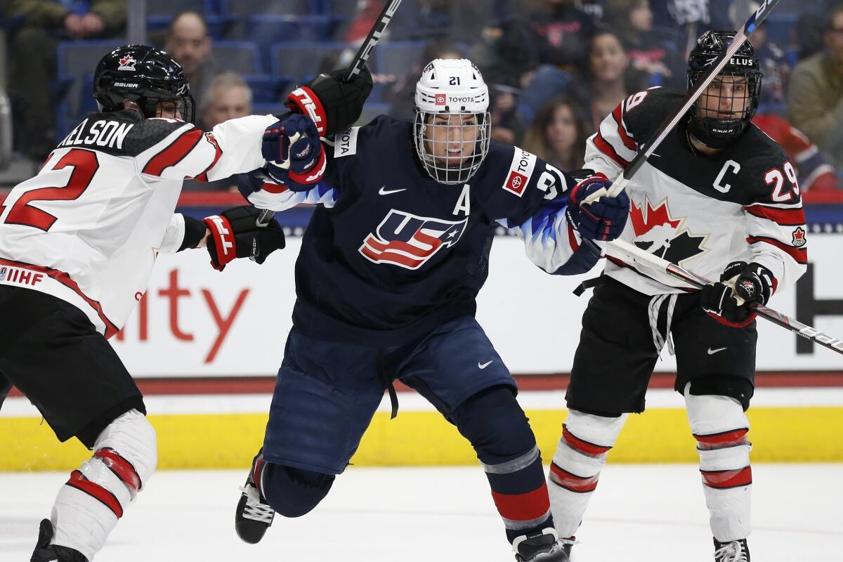 Hilary Knight, center, battles past a Canadian player during a game in 2019.