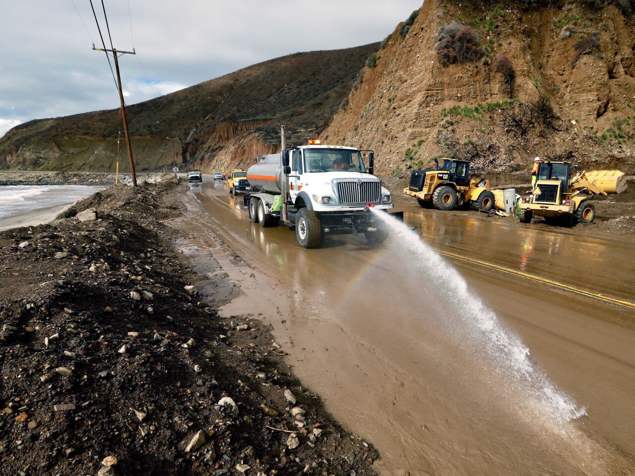 Trabajadores laboran para reabrir un tramo de la autopista de la costa del Pacífico, cerrada debido al lodo, en el condado de Ventura, al oeste de Malibu.