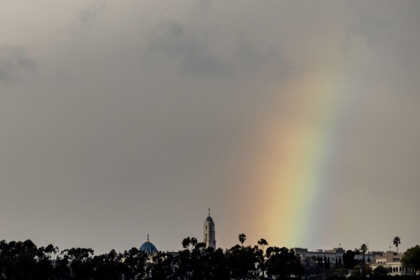 A rainbow rises behind the campus of the University of San Diego on Monday.