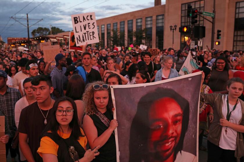 Supporters of Philando Castile held a portrait of Castile as they marched along University Avenue in St. Paul, Minn., leaving a vigil at the state Capitol on Friday, June 16, 2017. The vigil was held after St. Anthony police Officer Jeronimo Yanez was cleared of all charges in the fatal shooting last year of Castile. (Anthony Souffle/Star Tribune via AP)