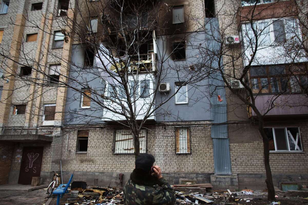 A man looks at an apartment block damaged by shelling in the eastern Ukrainian city of Donetsk on Monday. The continued fighting in Ukraine has strained Russia's relationships with European nations.
