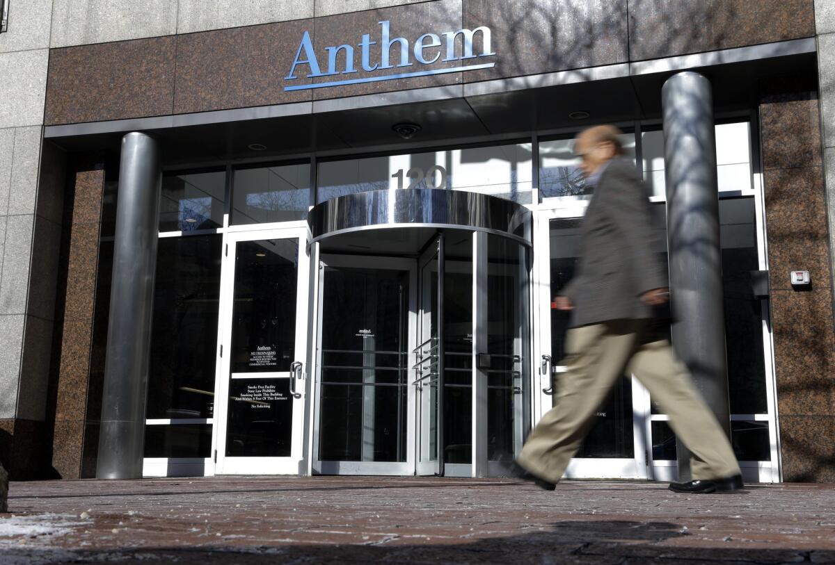 A man walks past health insurer Anthem's corporate headquarters in Indianapolis in 2015.