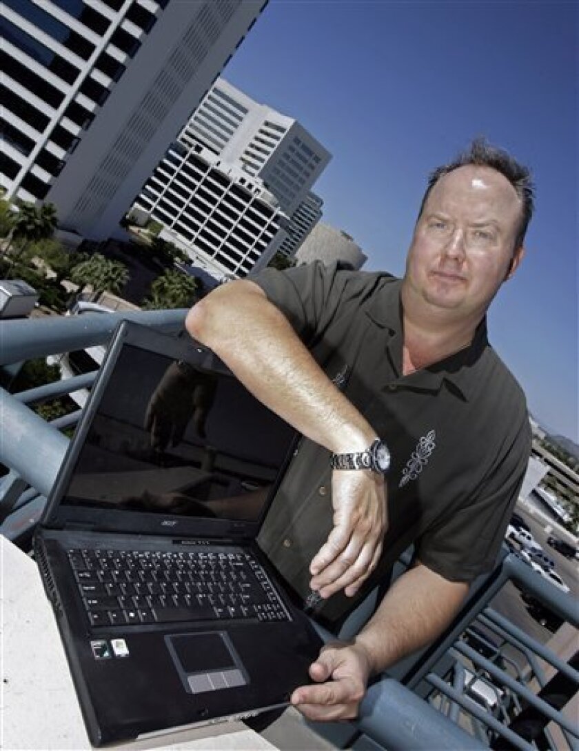 Blogger Jeffrey Pataky, who has been critical of the Phoenix Police Department on his Web site, poses for a photo in front of the downtown skyline Wednesday, April 8, 2009, in Phoenix. Pataky says police raided his home in retaliation and is suing the city for civil rights violations. (AP Photo/Paul Connors)