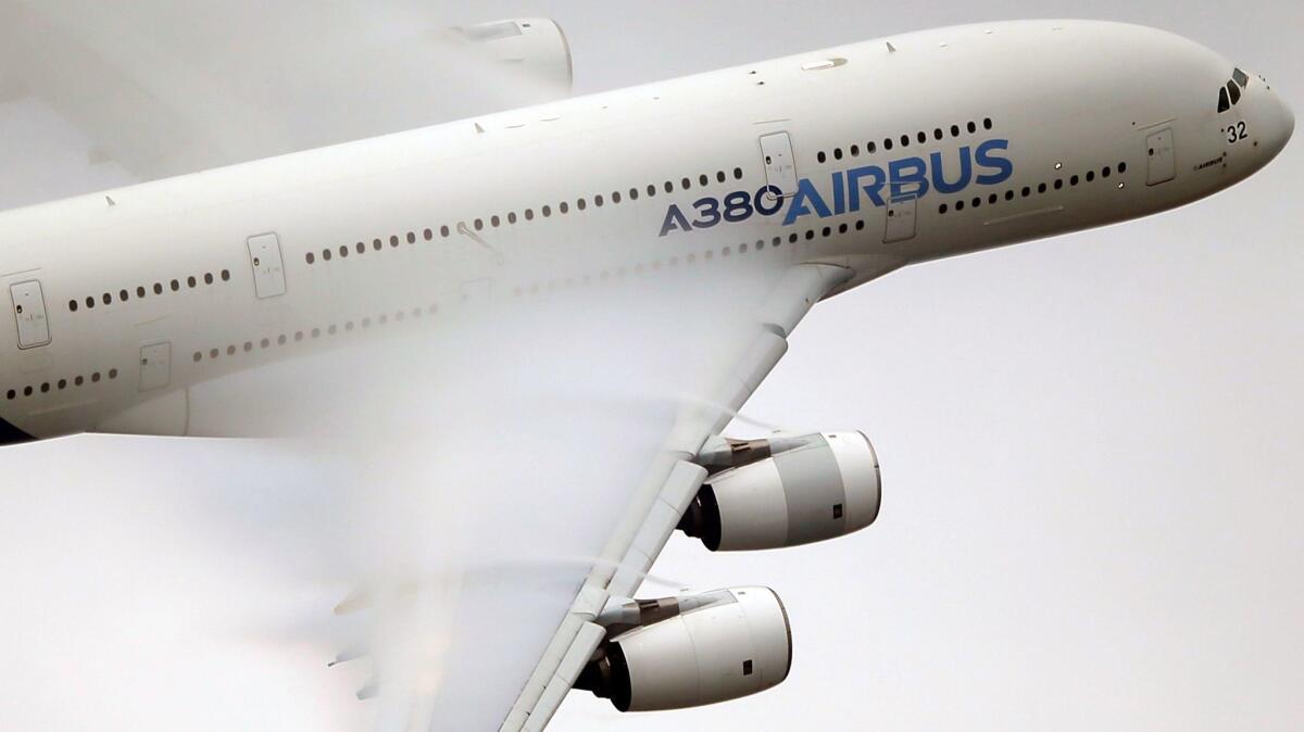 Vapor forms over the wings of an Airbus A380 as it performs a demonstration flight at the 2015 Paris Air Show.
