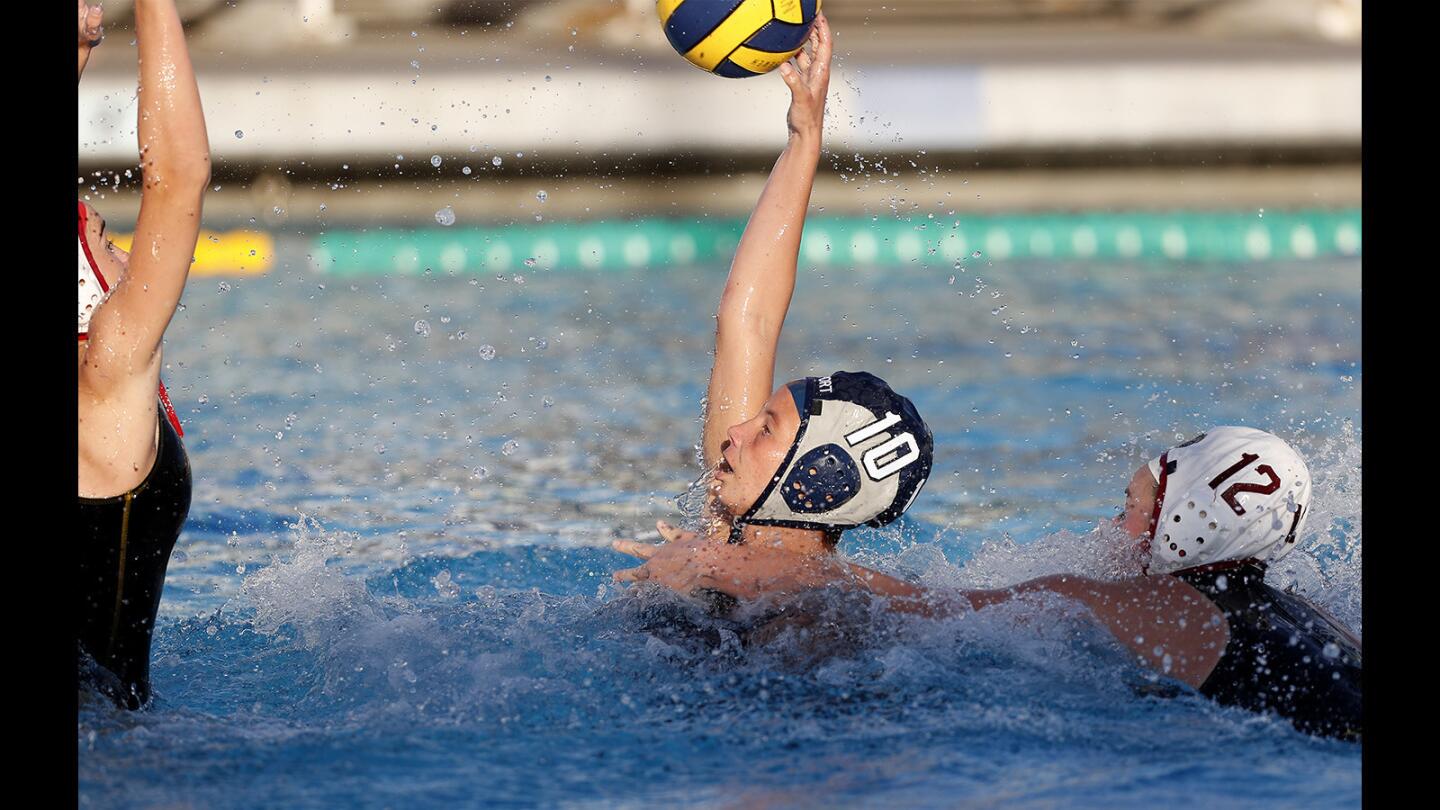 Newport Harbor High's Emily Cantu (10) floats the ball over Long Beach Wilson goalie Cameron Krueger, left, for a score during the first half in a nonleague game on Tuesday.