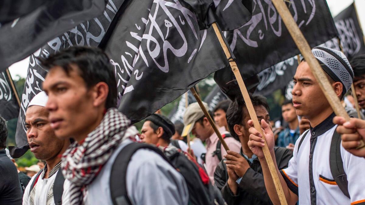 Indonesian Muslims wave Hizbut Tahrir's flag during a protest July 18 in Jakarta against a decree allowinag the country to ban groups that oppose its official state ideology.