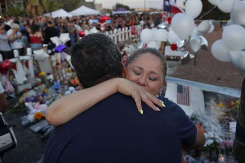 Mariana Cordero abraza a Gilbert Reza durante un acto de homenaje a las víctimas de una matanza en una tienda de El Paso, Texas.