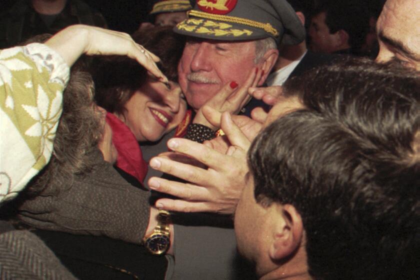 En esta imagen de archivo, el difunto dictador chileno, entonces comandante del ejército, general Augusto Pinochet, recibe el abrazo de una seguidora al encontrarse con partidarios que esperaban en su casa con motivo del 22do aniversario de su nombramiento como jefe de las fuerzas armadas chilenas, en Santiago, Chile, el 23 de agosto de 1995. Mientas Chile conmemora el 11 de septiembre de 2023 el 50 aniversario del golpe que llevó a Pinochet al poder, las encuestas muestran que un tercio de los chilenos justifican hoy en día su toma de poder derrocando a un gobierno elegido democráticamente, que derivó en violaciones de los derechos humanos, asesinato de opositores, cancelación de elecciones, restricciones a la prensa, supresión de los sindicatos y desmantelamiento de partidos políticos. (AP Foto/Santiago Llanquin, archivo)
