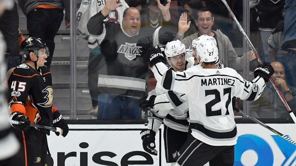 Kings center Nick Shore (21) celebrates his game-winning goal with right wing Dustin Brown, back right, and defenseman Alec Martinez, front right, as Ducks defenseman Sami Vatanen skates by during overtime on Tuesday.