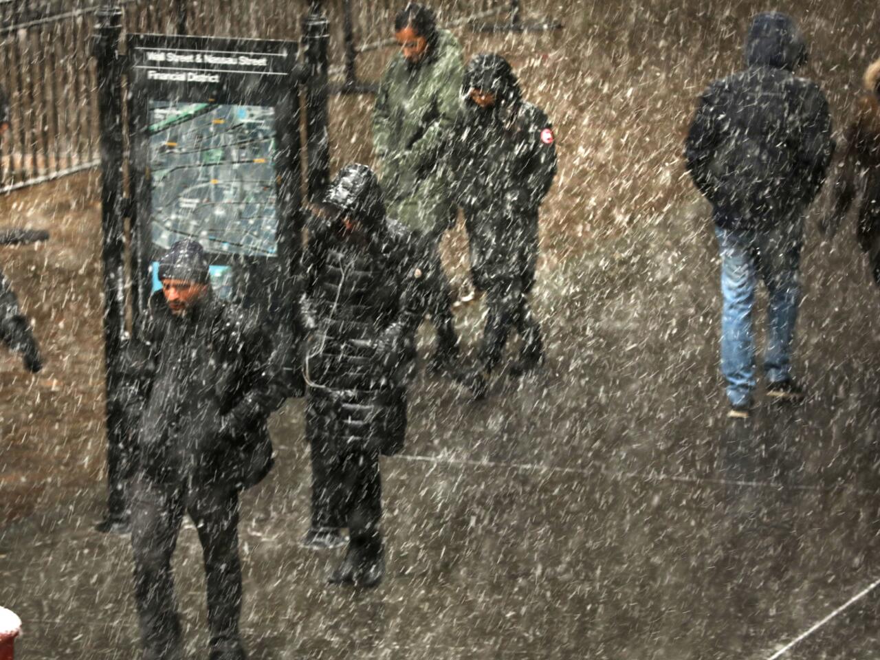 People walk through the snow in lower Manhattan as extremely cold temperatures are predicted for New York City in the coming days as a Polar Vortex, which is now over parts of the midwest, heads towards the region.