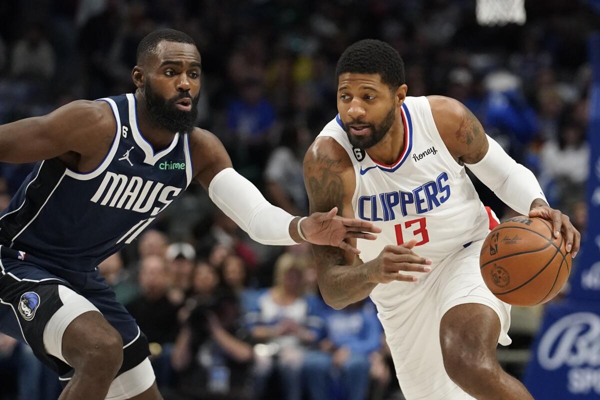 Paul George drives against a Dallas Mavericks player. 