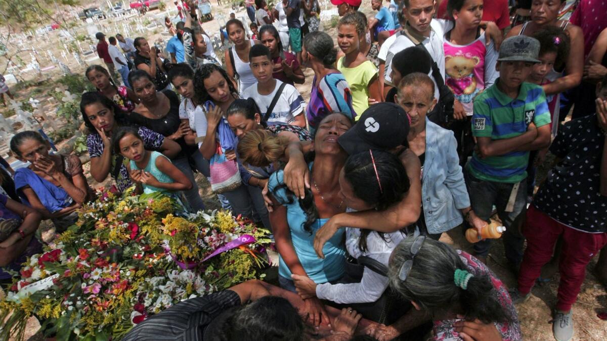 Relatives grieve Friday during the funeral of some of the victims of the prison fire in Valencia, Venezuela, in central Carabobo state.