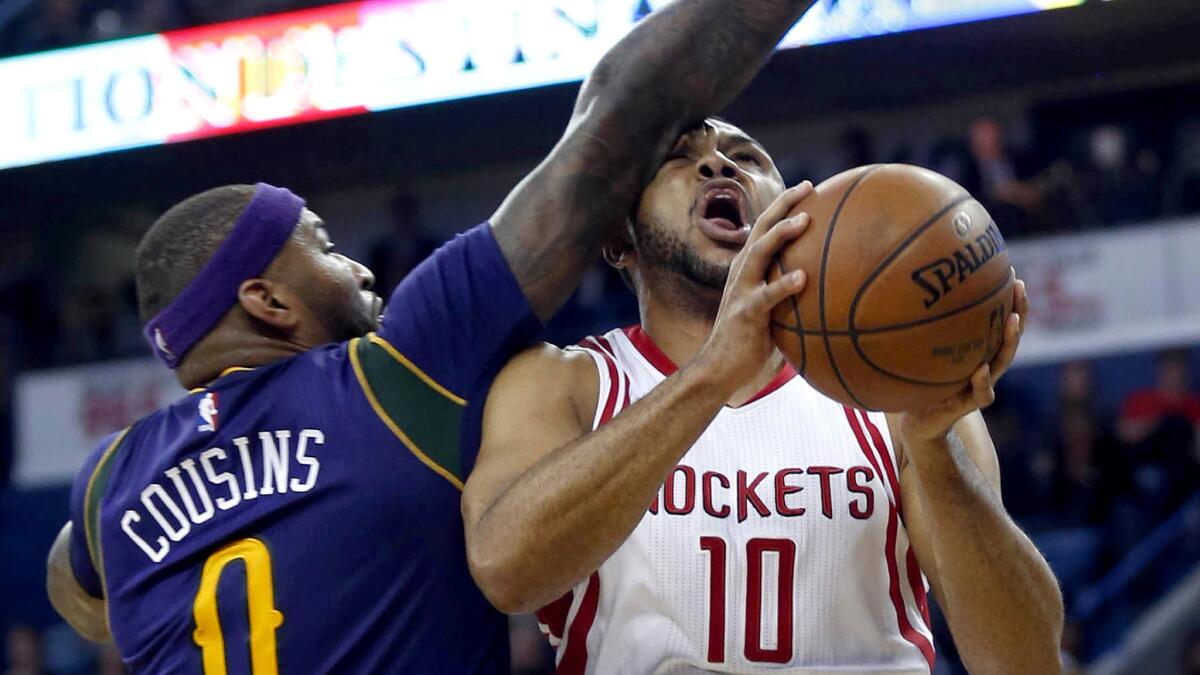 Rockets guard Eric Gordon (10) takes an arm to the face from Pelicans center DeMarcus Cousins (0) during the first half Thursday night.