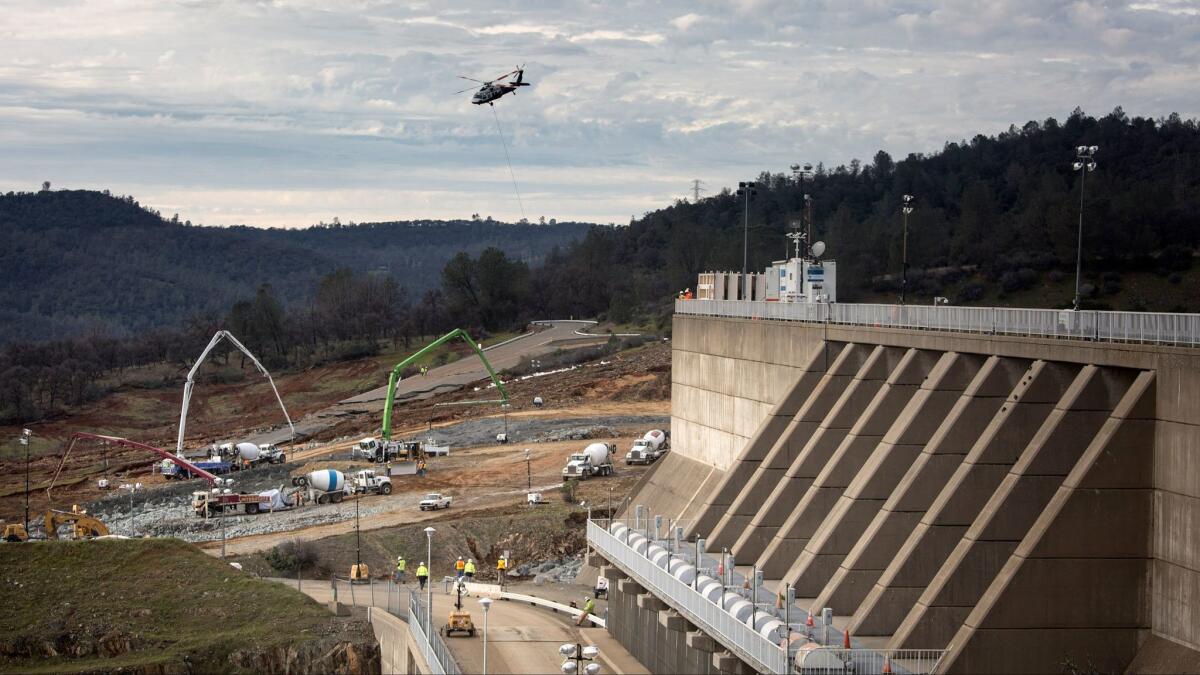 Reconstruction continued Wednesday in a race to shore up the emergency spillway, left, at the Oroville Dam.