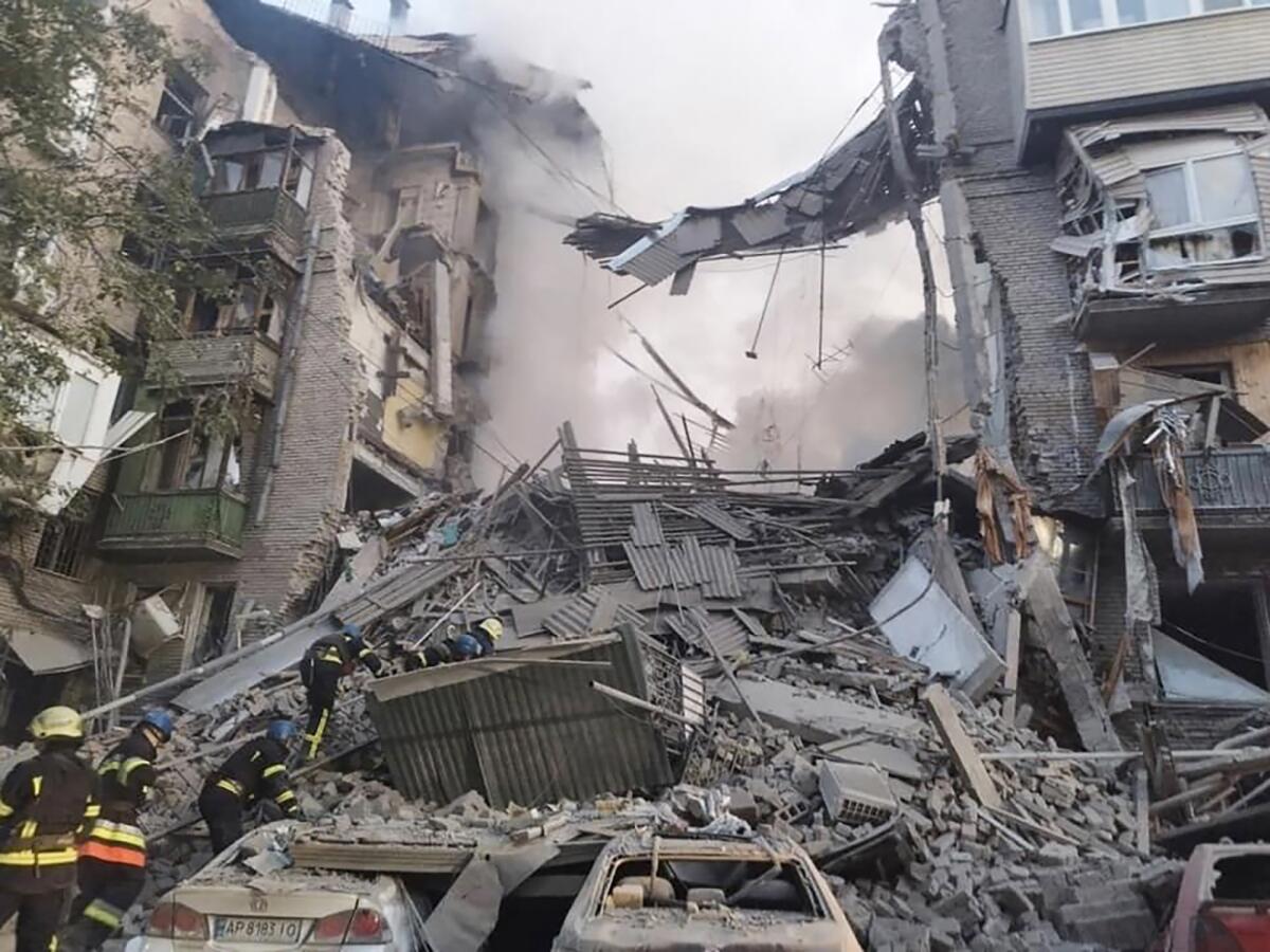 An apartment building is partially collapsed onto cars in Ukraine.