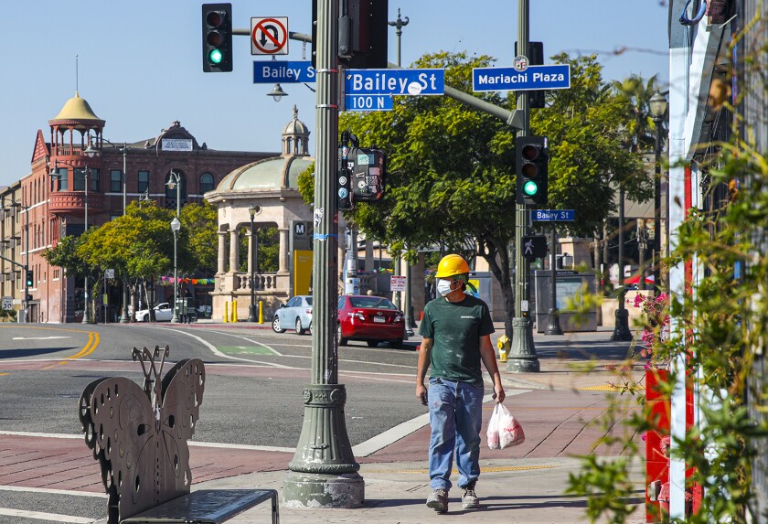 A worker crosses Mariachi Plaza at Bailey Street