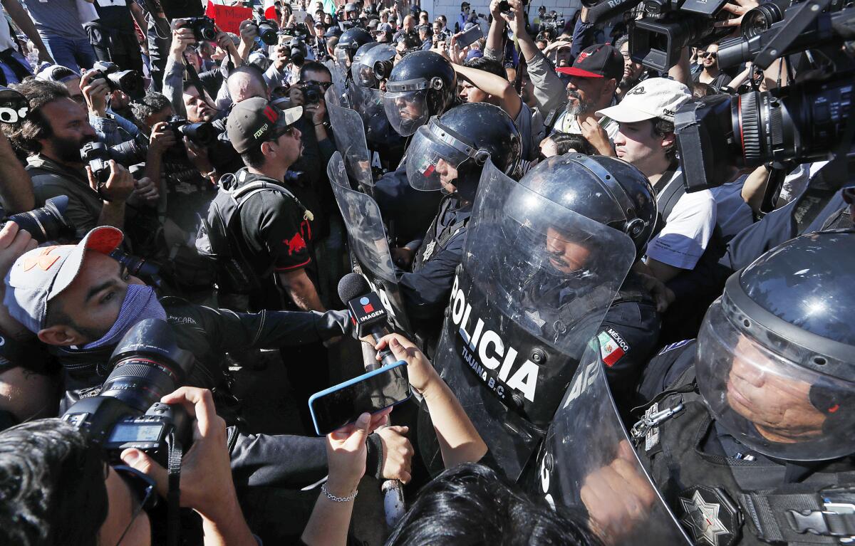 Protesters clash with police guarding a sports facility in Tijuana where more than 2,000 Central immigrants are sheltered.