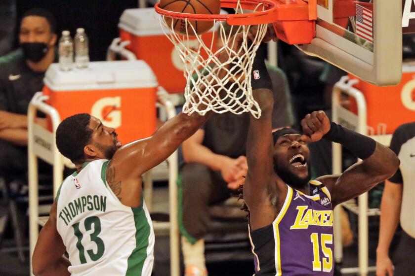 LOS ANGELES, CA - APRIL 15: Los Angeles Lakers Montrezl Harrell drives and scores against Boston Celtics Tristan Thompson in the first quarter on Thursday, April 15, 2021. This was the first Lakers game in over a year with fans. (Myung J. Chun / Los Angeles Times)