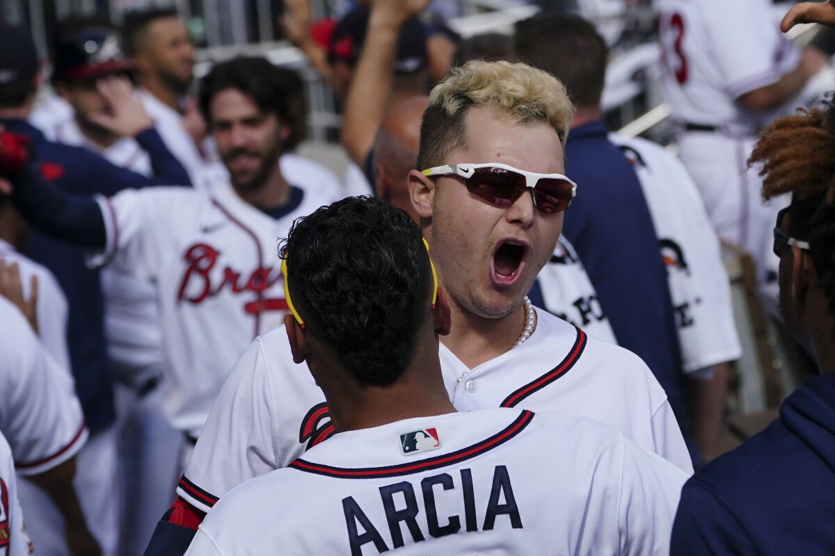 Atlanta Braves' Joc Pederson (22) celebrates his three-run homer in the dugout against the Milwaukee Brewers during the fifth inning of Game 3 of a baseball National League Division Series, Monday, Oct. 11, 2021, in Atlanta. (AP Photo/John Bazemore)