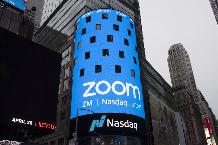 FILE - This April 18, 2019, file photo shows a sign for Zoom Video Communications ahead of the company's Nasdaq IPO in New York. Videoconferencing service Zoom is buying cloud contact center provider FiveTh9 in an all-stock deal valued at about $14.7 billion. Zoom Video Communications Inc. founder and CEO Eric Yuan said in a blog post that the acquisition will allow the company to accelerate its long-term growth by adding the $24 billion contact center market. (AP Photo/Mark Lennihan, File)
