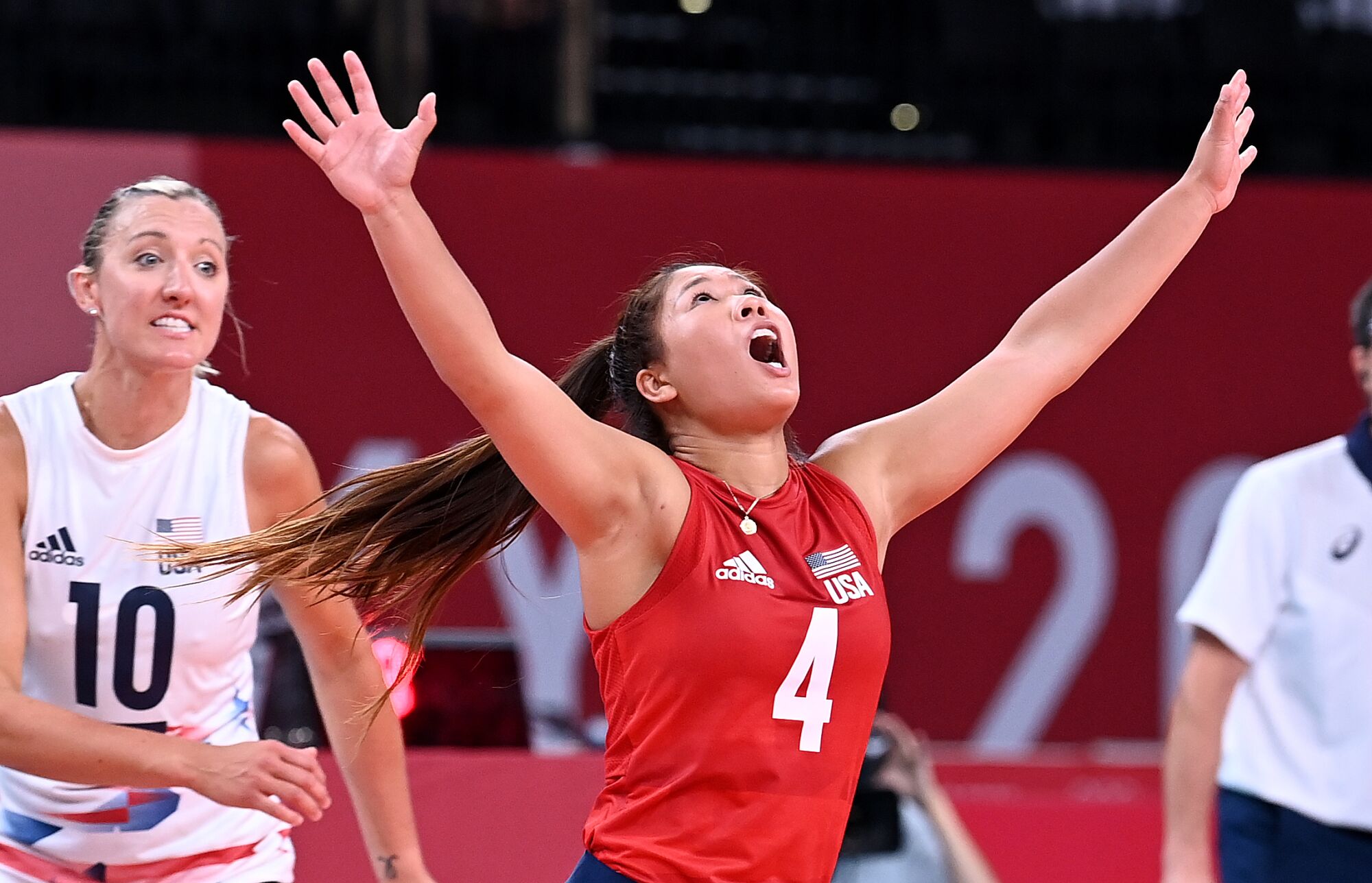 A woman shouts skyward with both arms outstretched.