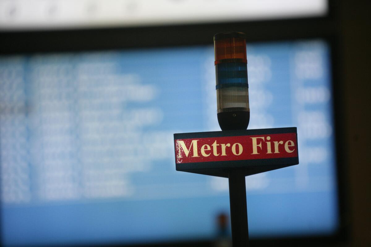 A Metro Fire sign hovers over the desks of dispatchers at the Los Angeles Fire Department Dispatch Center.