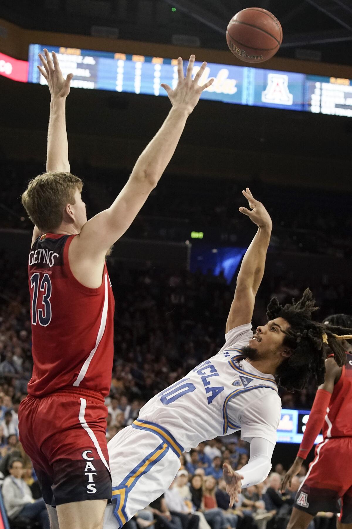 UCLA guard Tyger Campbell lofts a shot over Arizona forward Stone Gettings during the second half Saturday night at Pauley Pavilion.