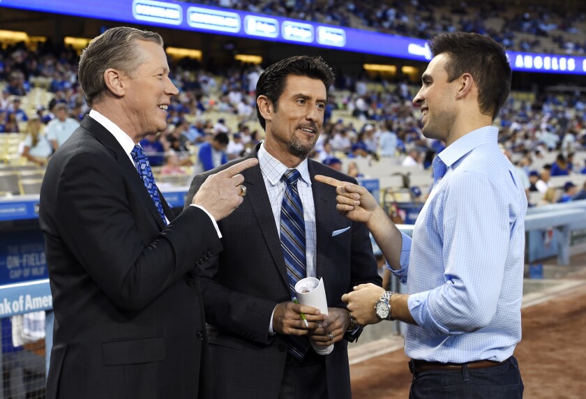 Dodgers broadcasters Orel Hershiser, Nomar Garciaparra and Joe Davis chat before a game.