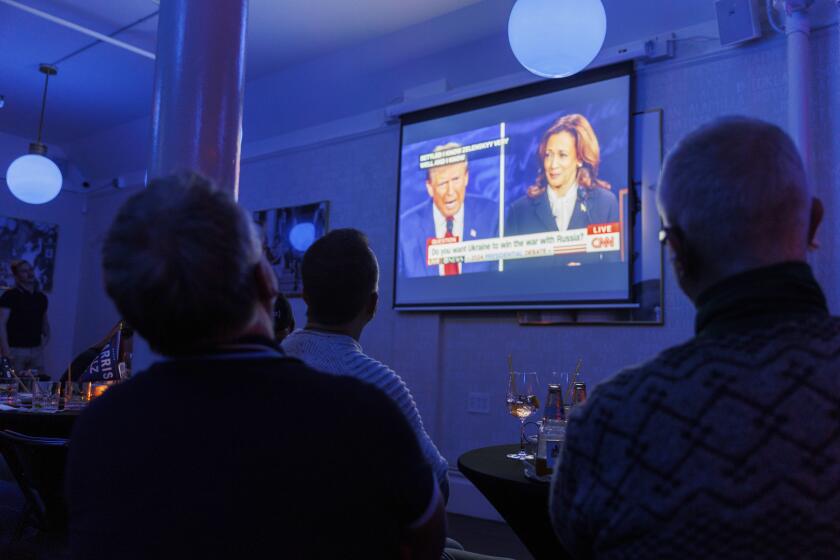 People watch a presidential debate between Republican presidential nominee former President Donald Trump and Democratic presidential nominee Vice President Kamala Harris at a watch party hosted by the Alice B. Toklas LGBTQ Democratic Club at the Academy on Tuesday, Sept. 10, 2024, in San Francisco. (AP Photo/Juliana Yamada)