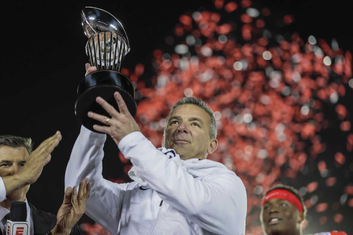 Ohio State coach Urban Meyer hoists the Rose Bowl trophy after leading the Buckeyes to a 28-23 win over the Washington Huskies in his final game.
