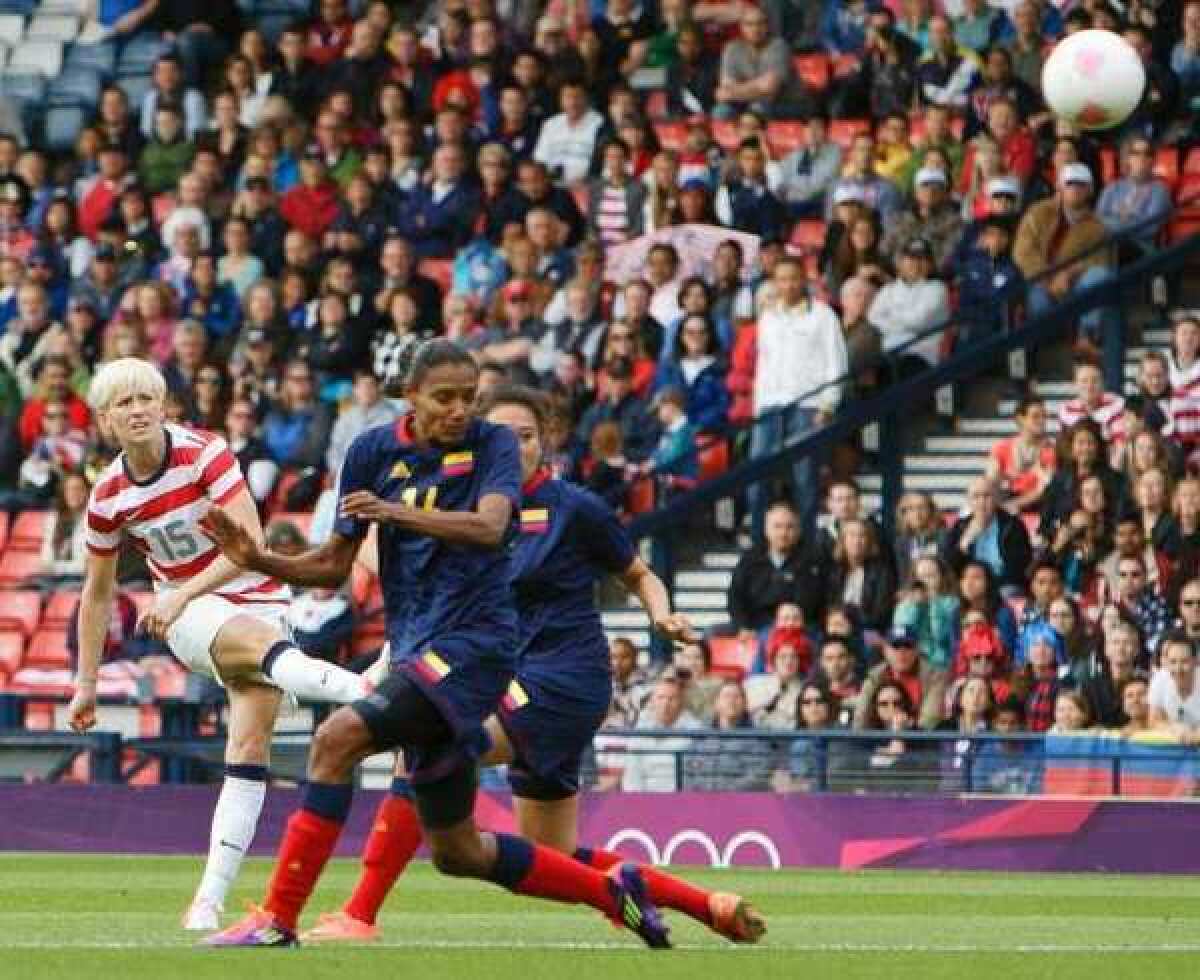 Megan Rapinoe, left, of the U.S. shoots and scores the first goal against Colombia.