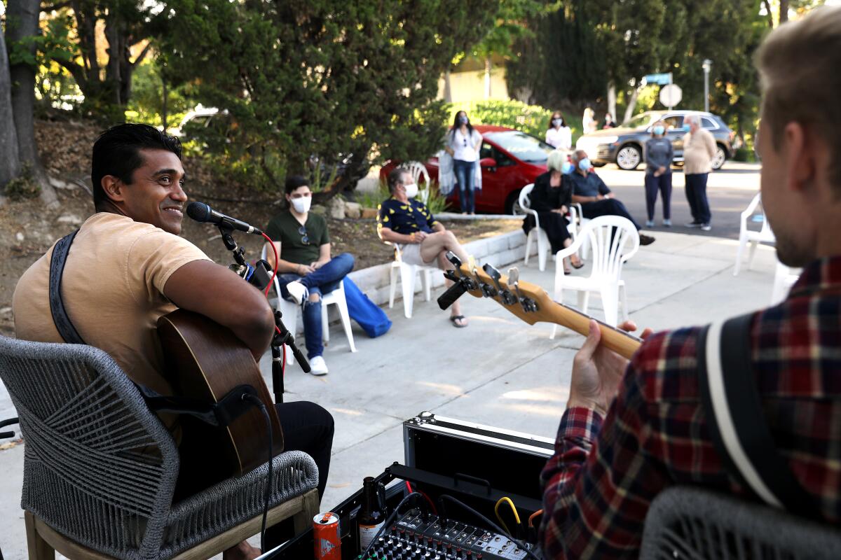 Musicians Dilan Jay, left, and Evan Miranda play in the driveway of Jay's home in Tarzana on Friday, May 22, 2020. 