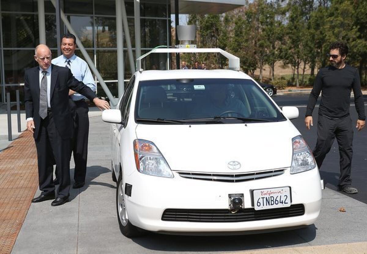 California Gov. Jerry Brown, state Sen. Alex Padilla and Google co-founder Sergey Brin exit a self-driving car at the Google headquarters in Mountain View.