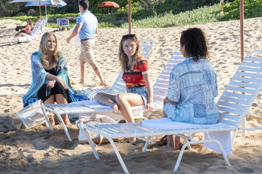 A middle-aged woman and two college students on beach chairs