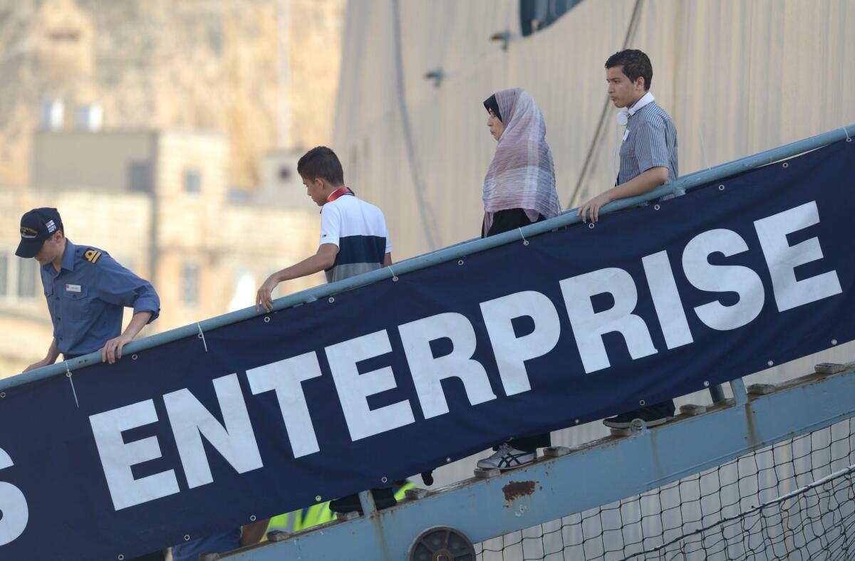 A family disembarks Monday from the British ship Enterprise shortly after docking in Valletta, Malta. The ship evacuated 110 Britons from Libya.