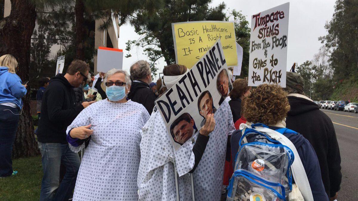 Protesters don hospital gowns and surgical masks outside Rep. Darrell Issa's Vista office in May to protest his vote on the GOP healthcare bill.