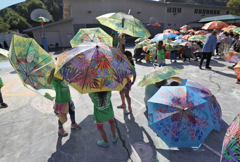 Kids open colorful umbrellas during "Look Up"  on the playground at the Boys & Girls Club of Laguna Beach. 