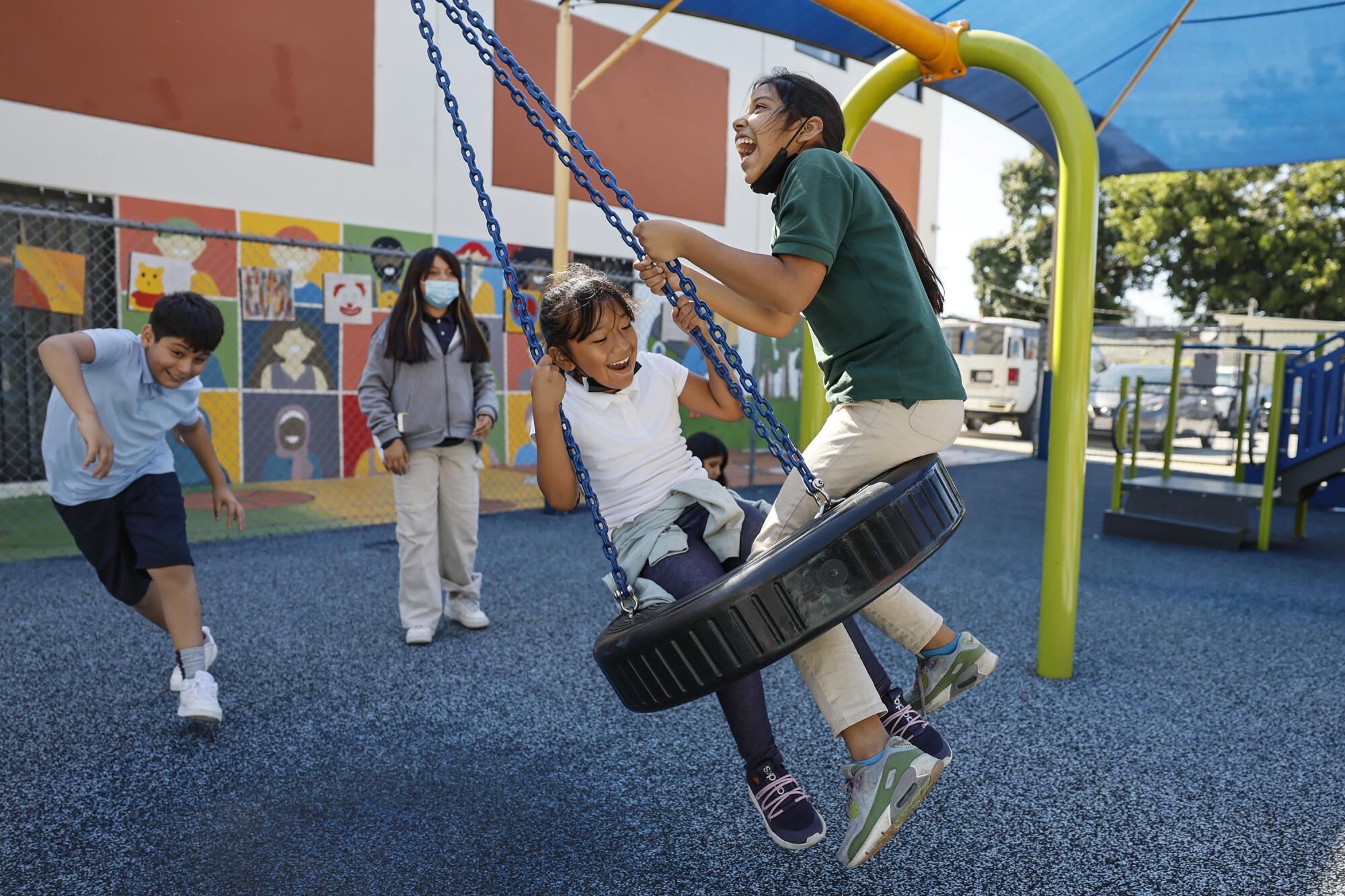 Children play on a tire swing and on the playground at the All Peoples Community Center. 