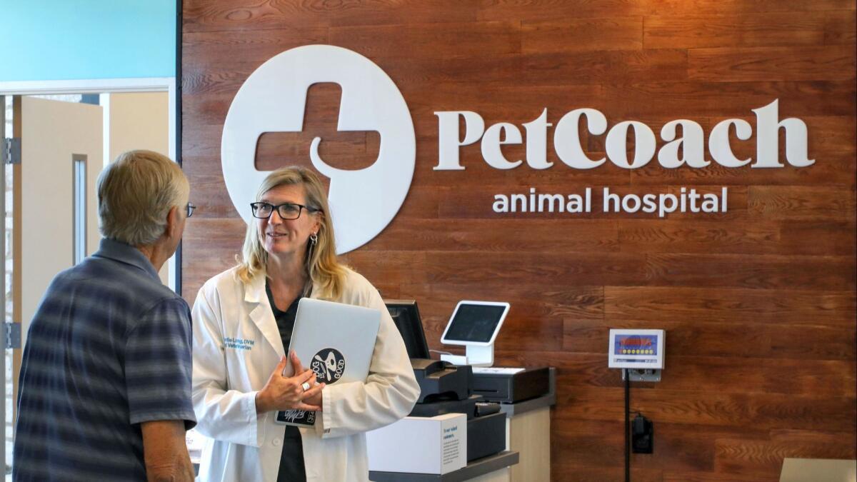 Veterinarian Christie Long speaks to a customer at the animal hospital of the new PetCoach store.