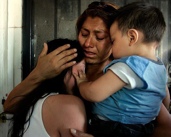 Veronica Cervantes, whose brother was among those shot to death, is consoled by Carmina Rosas and her baby Luis. Veronica ran to the street when she heard gunshots and found her brother Luis mortally wounded.