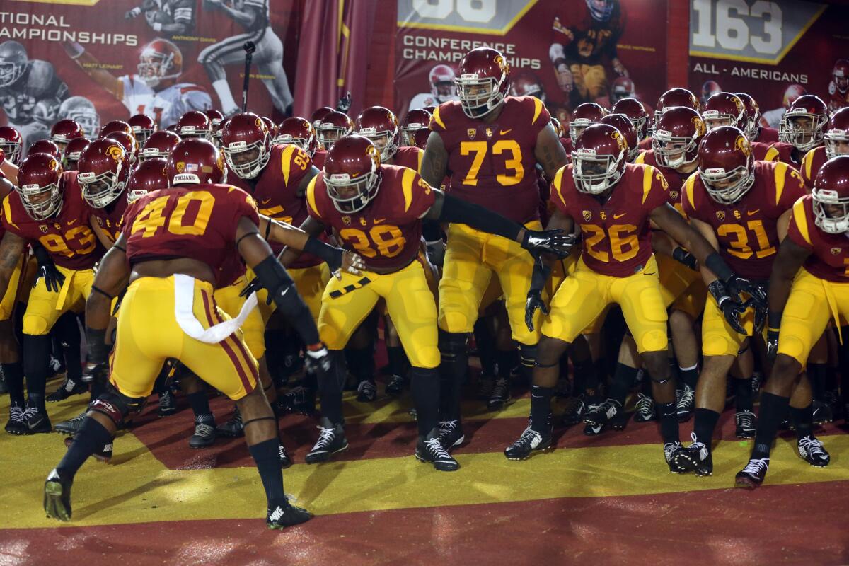 Trojans football players get pumped up before taking the field for their season-opening game against Arkansas State on Saturday night.