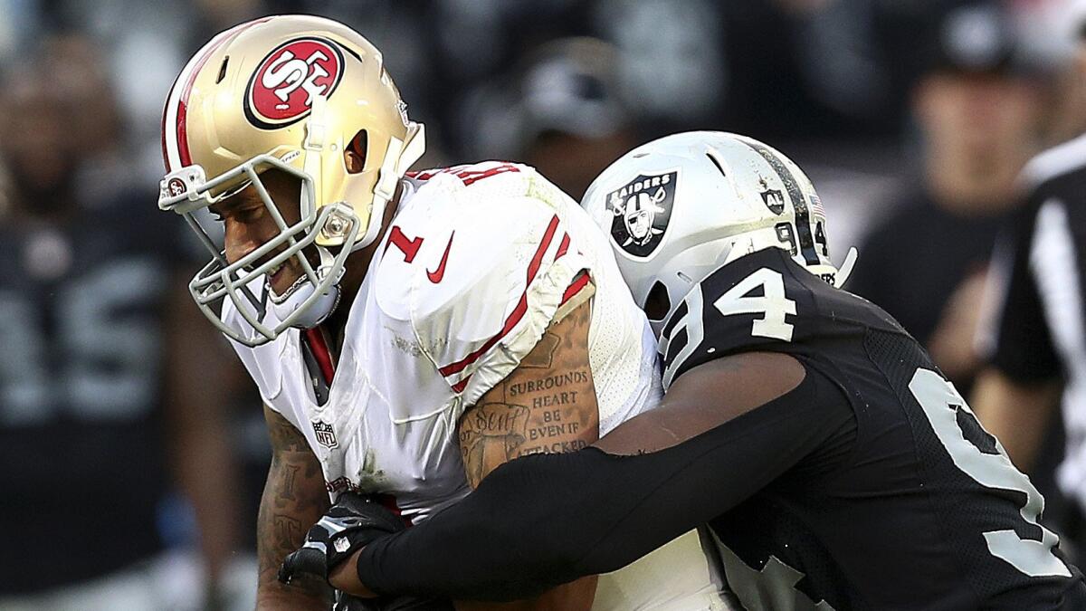 San Francisco 49ers quarterback Colin Kaepernick, left, is sacked by Oakland Raiders defensive tackle Antonio Smith during the second half of the Raiders' 24-13 win Sunday.