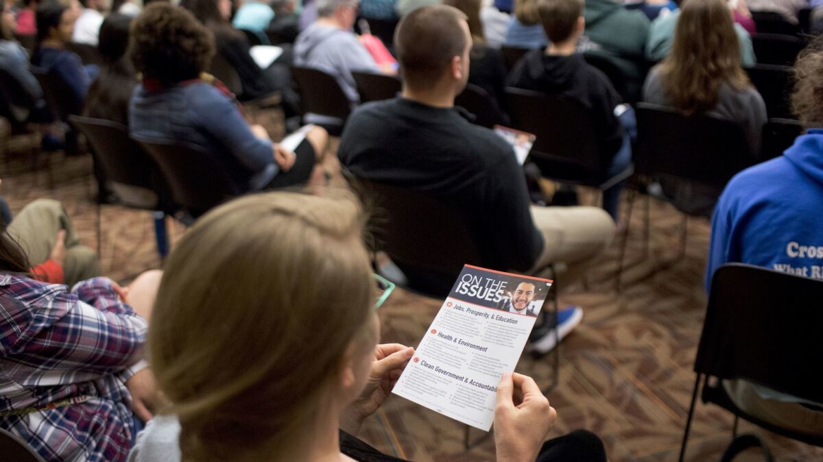 A woman holds an informational card about El-Sayed during a town hall event at Hope College.
