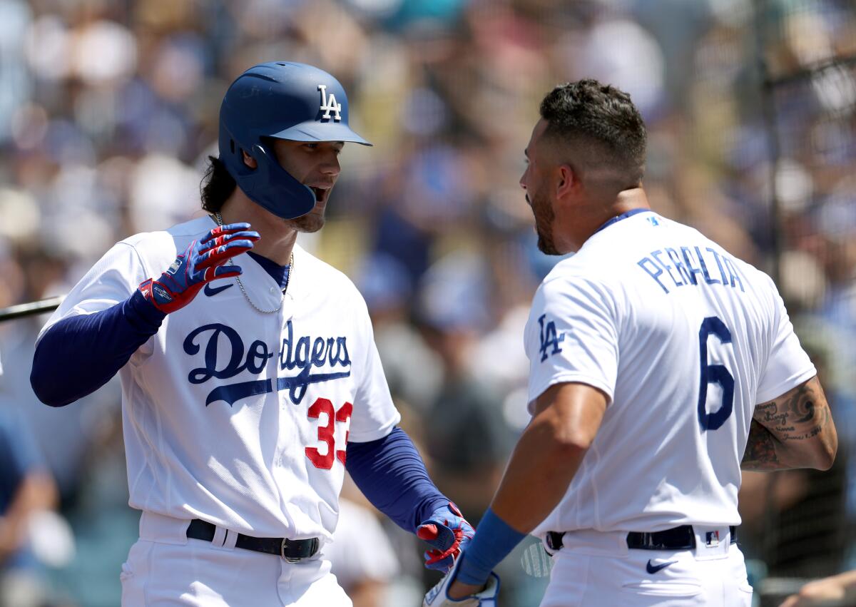 Dodgers center fielder James Outman, left, celebrates with teammate David Peralta.