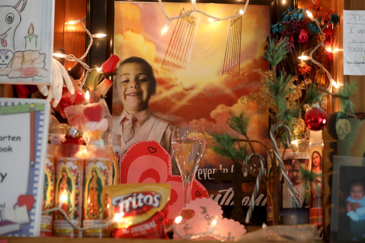 A memorial for Anthony Avalos has photos, candles, twinkling lights and cards