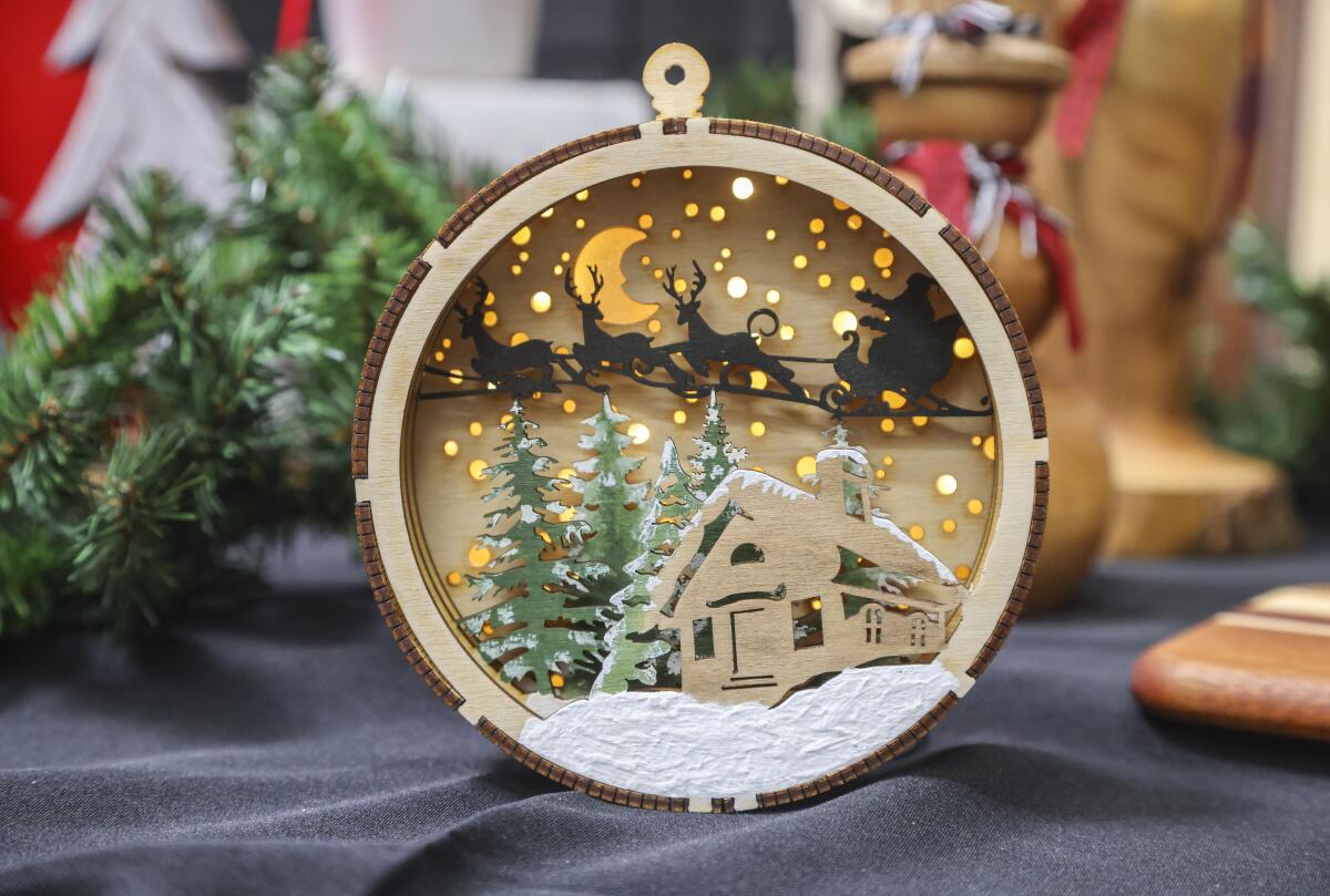 A light-up tree ornament in the 2022 gift sale shows intricate detail work by a local woodworker.