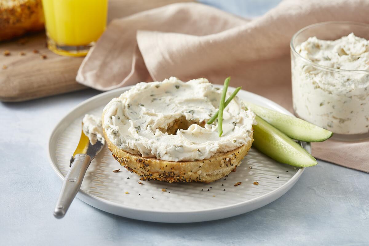 A bagel with a chive and onion spread