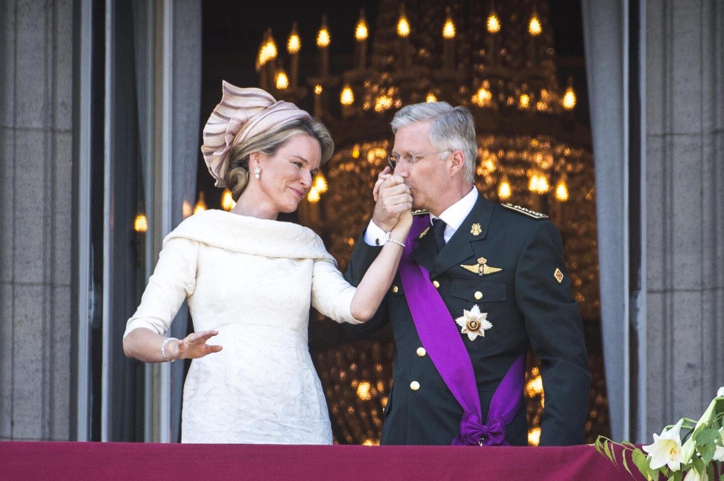 King Philippe of Belgium kisses the hand of his wife, Queen Mathilde, on the balcony of the royal palace in Brussels.