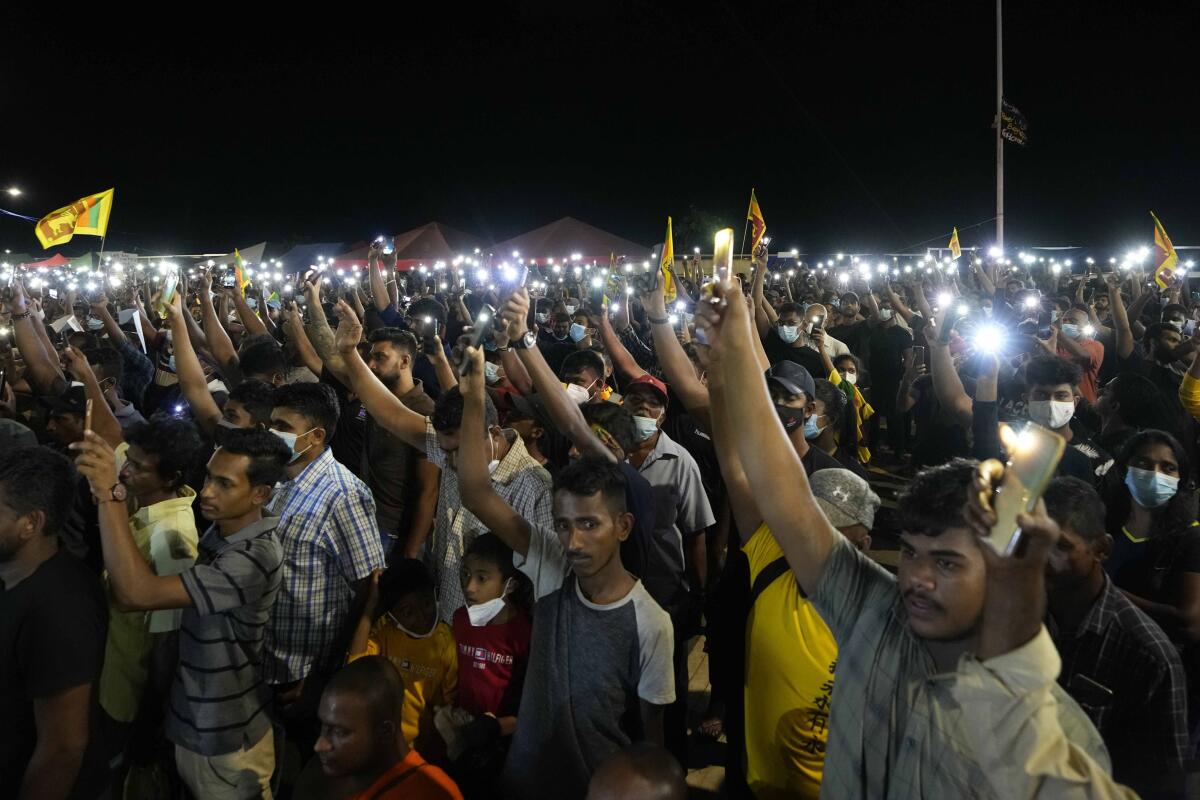 Protesters raising lit-up cellphones