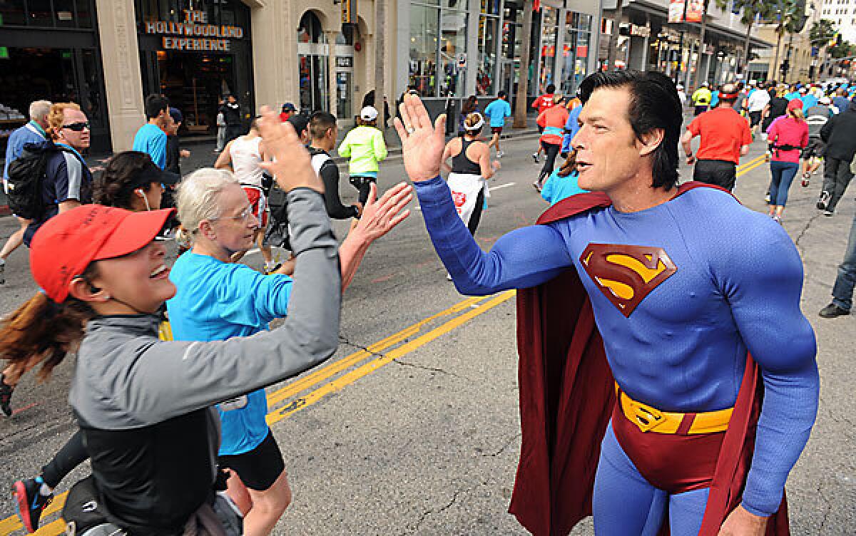 Christopher Dennis anima a los corredores a lo largo de Hollywood Boulevard durante el Maratón de Los Ángeles 2012. (Wally Skalij / Los Angeles Times)